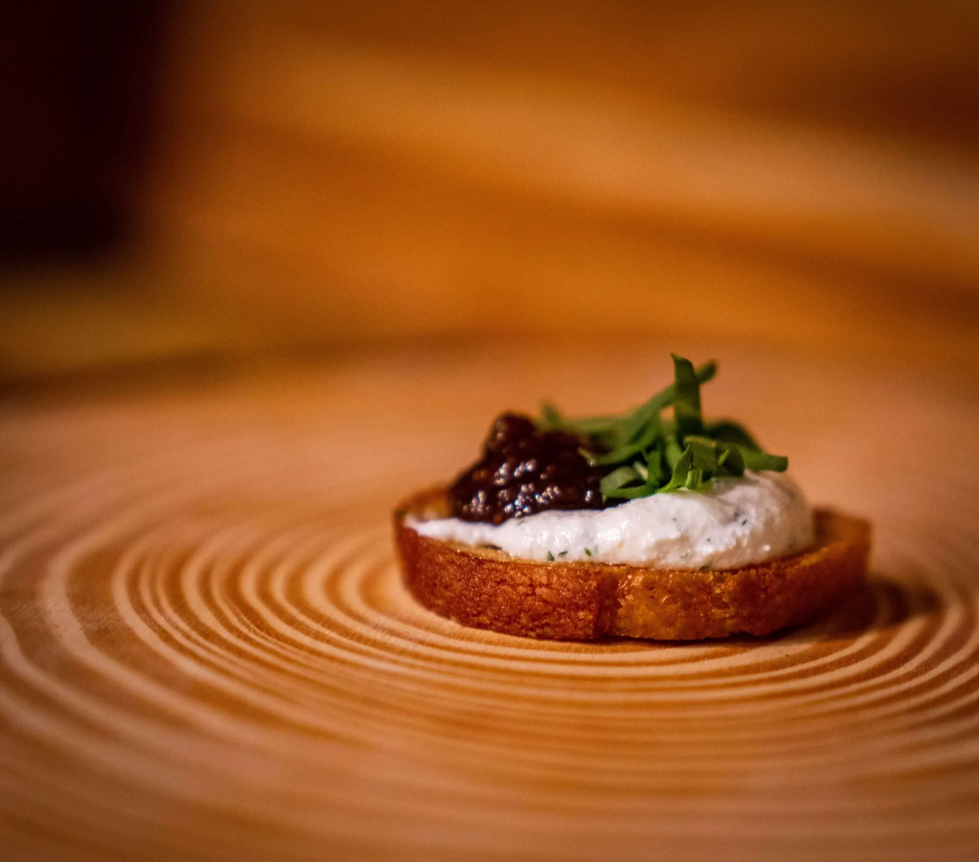 Crostini topped with herbed ricotta, fig jam, and microgreens