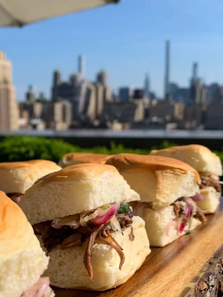 Pulled pork sliders with pickled onions before the Manhattan skyline