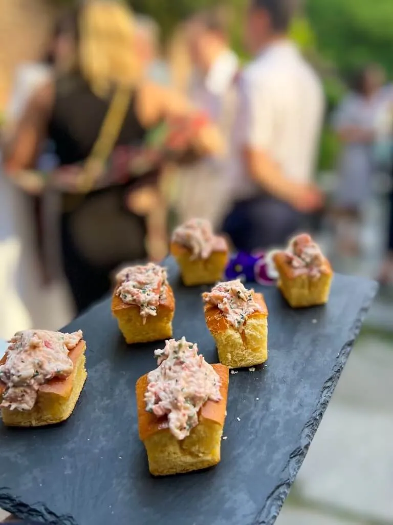 Seafood salad crostini on a slate board at an outdoor party