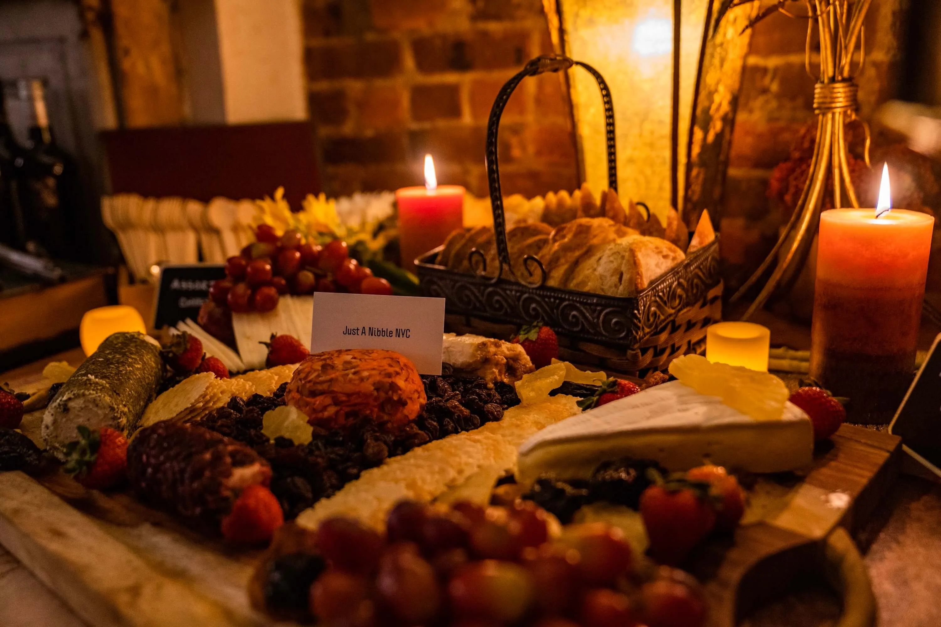 Candlelit charcuterie and cheese board with a Just a Nibble NYC card