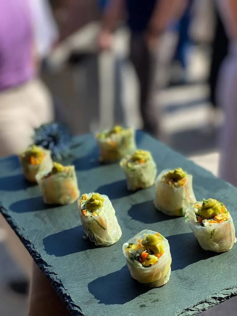 Slate board of vegetable summer rolls with avocado