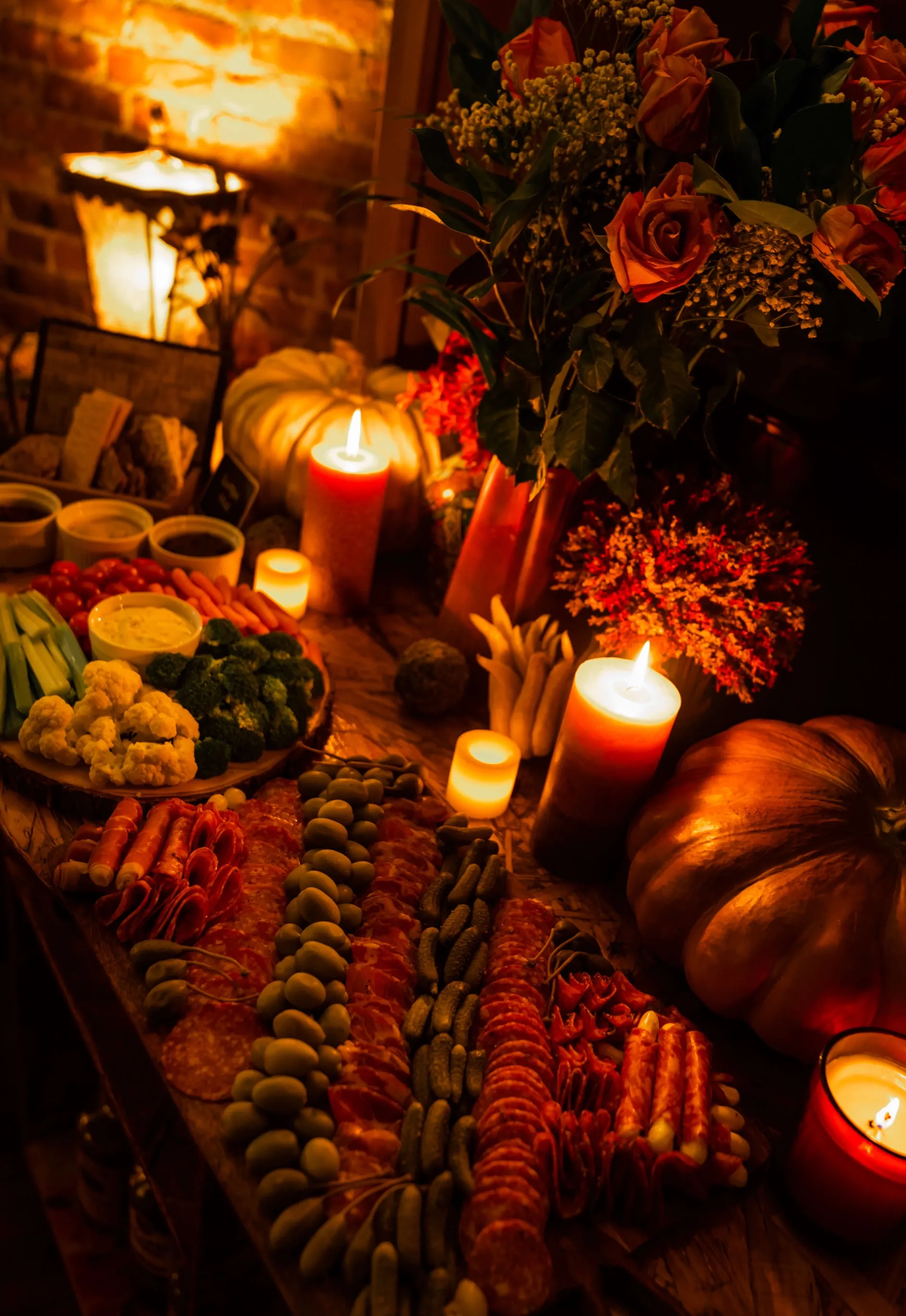 Autumn grazing table with charcuterie, crudités, pumpkins, and candles
