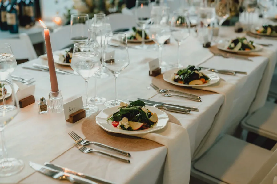 Plated salads at an elegant candlelit dinner table