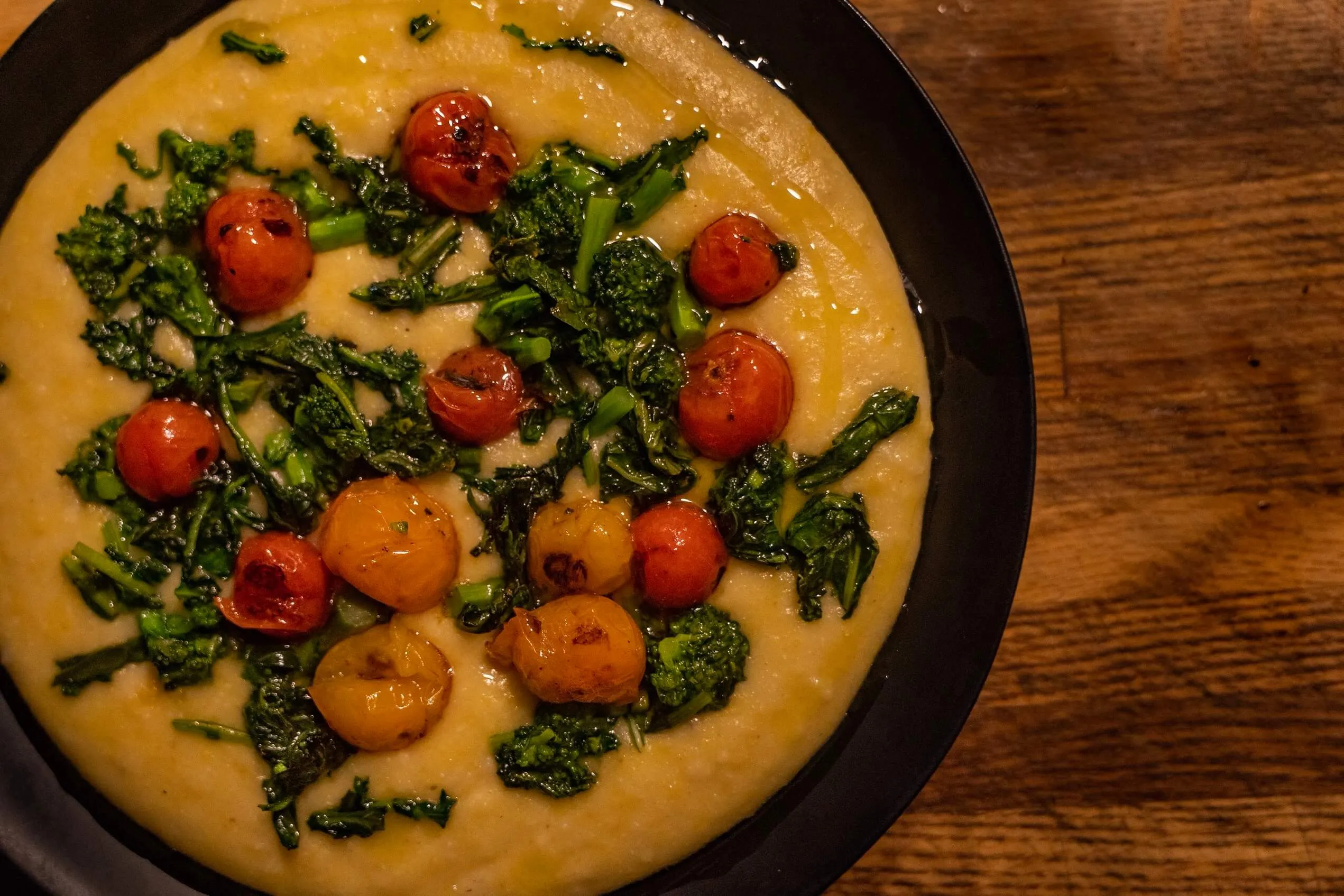 Creamy polenta topped with roasted broccolini and blistered cherry tomatoes
