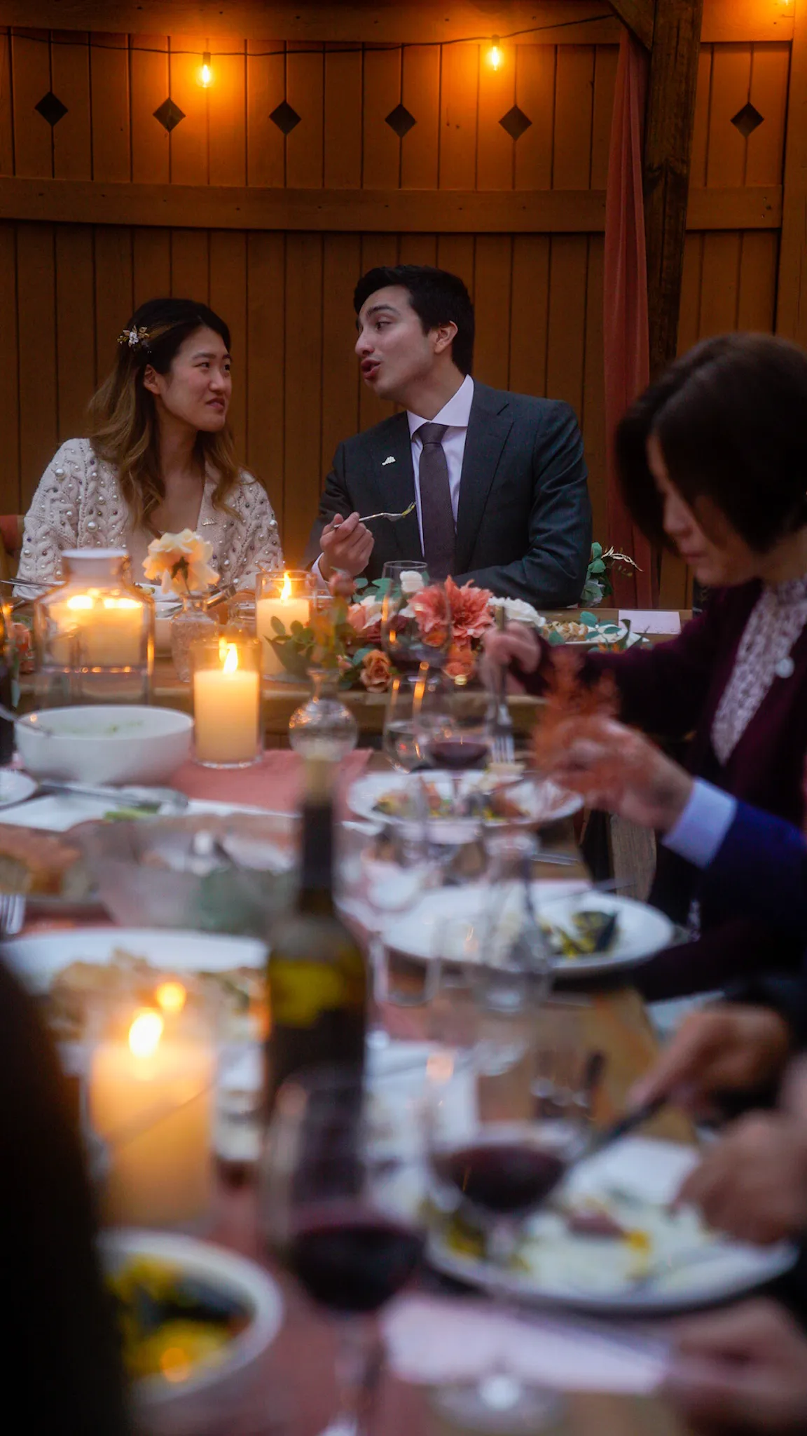 Couple dining by candlelight at an outdoor evening reception