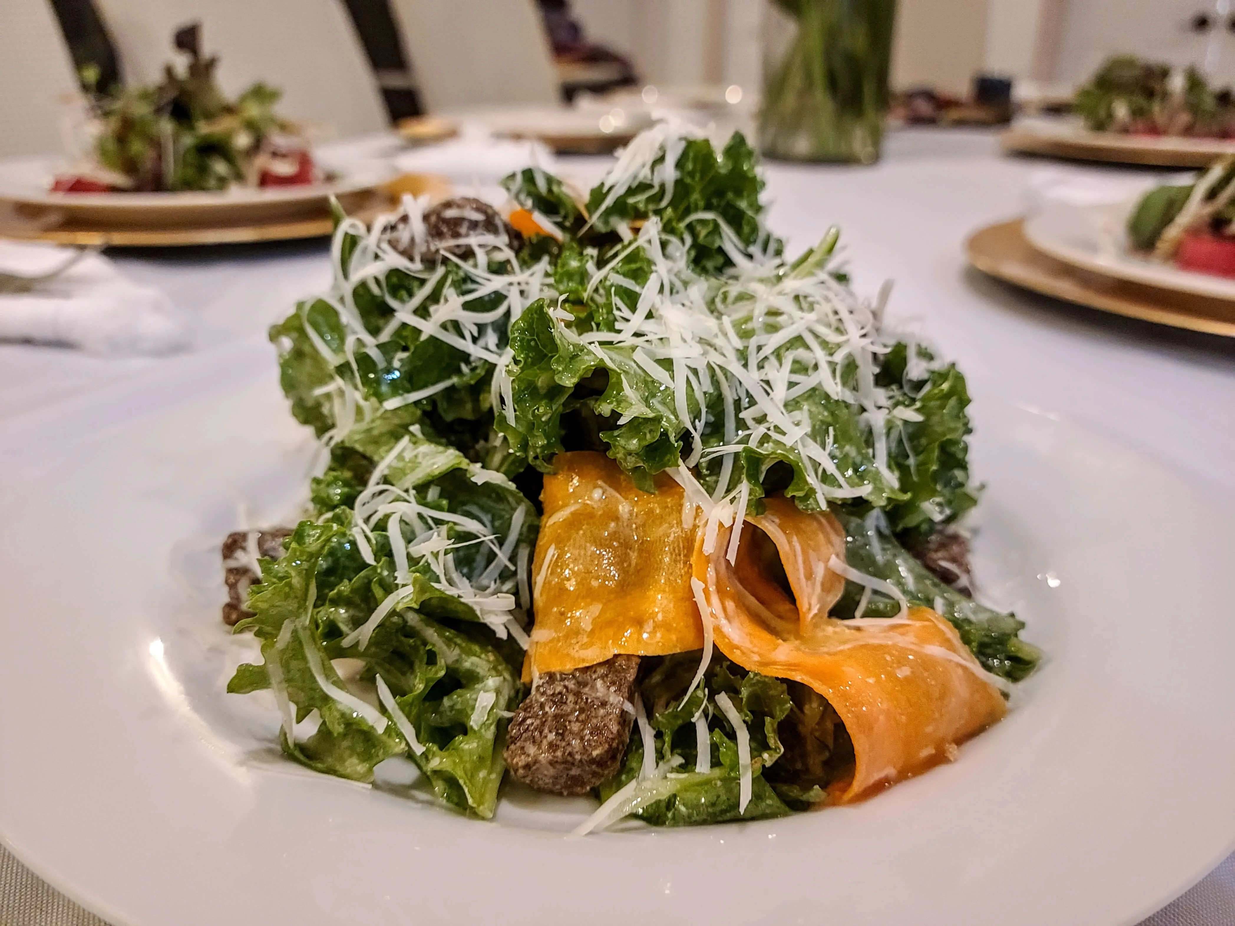 Kale Caesar salad with shaved parmesan, croutons, and roasted squash