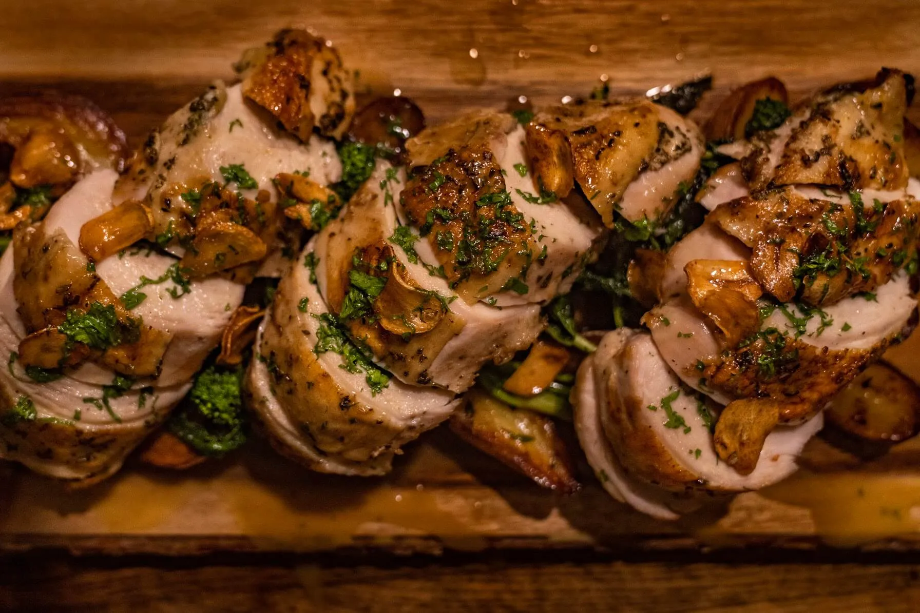 Carved herb-roasted chicken with garlic chips and parsley