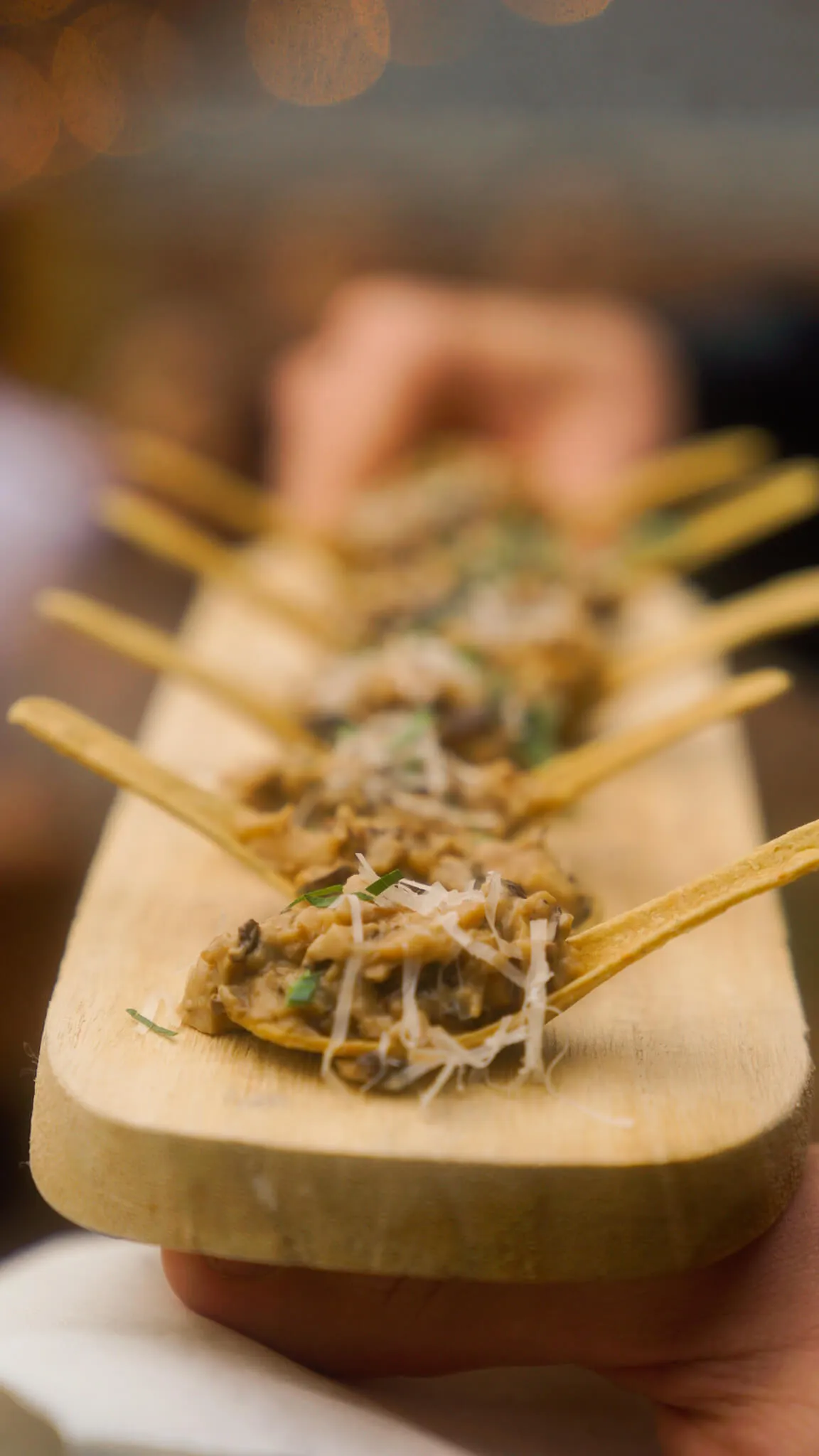 Creamy mushroom appetizers on tortilla spoons topped with grated cheese