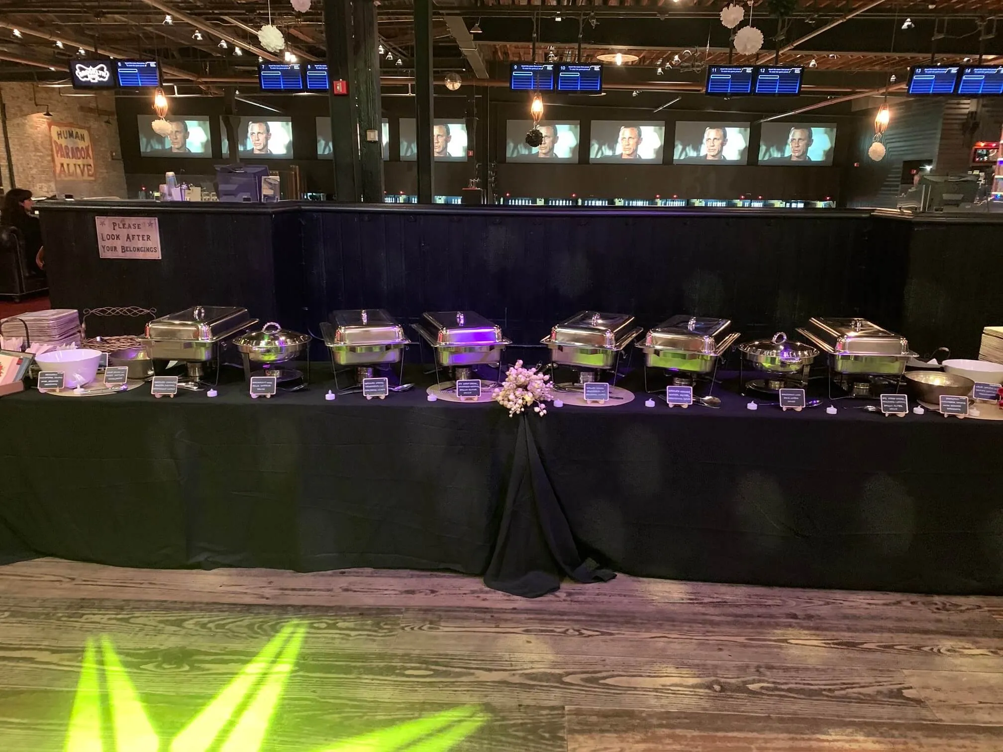 Row of stainless chafing dishes on a black buffet table