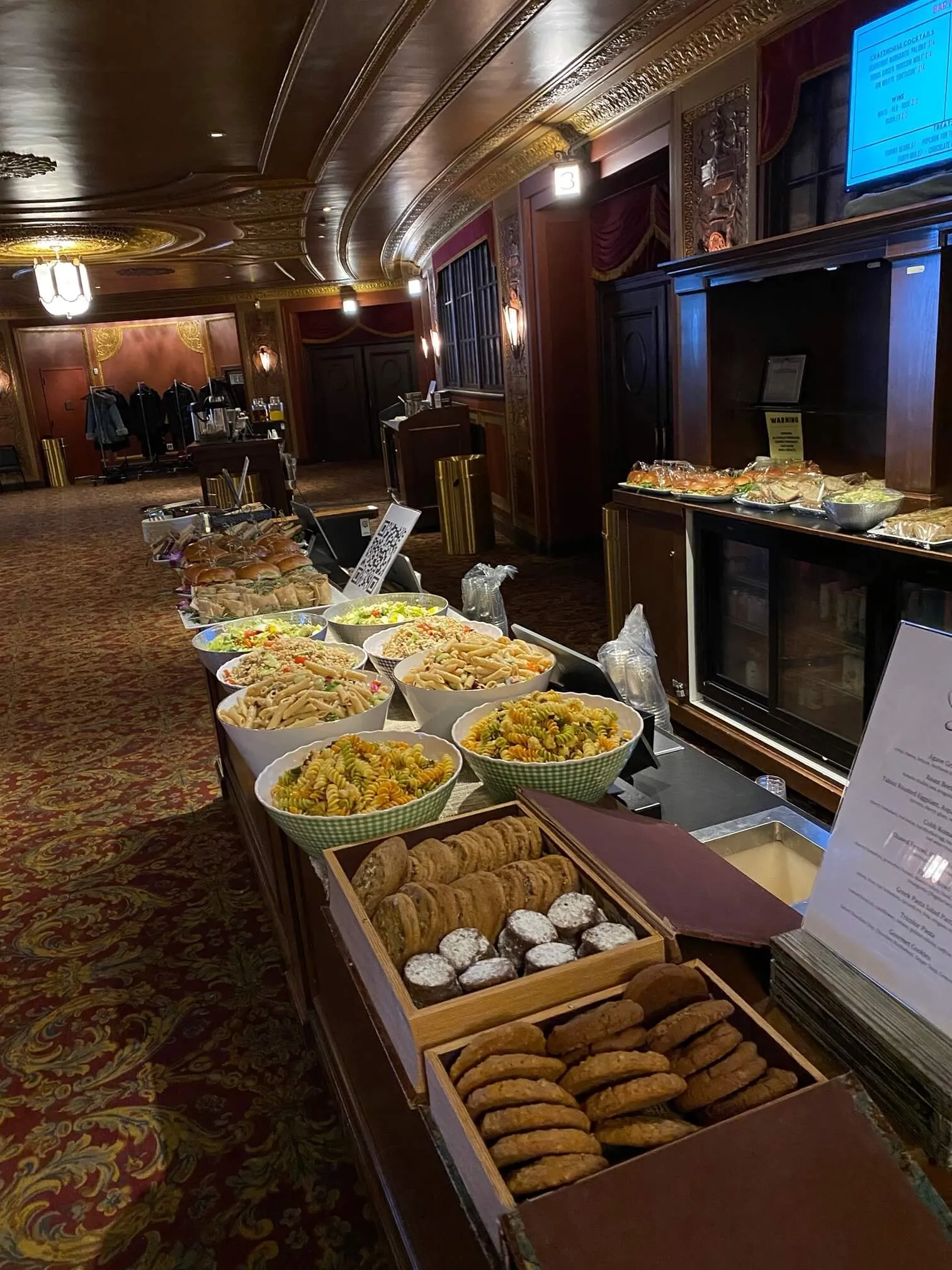 Buffet of pasta salads, sandwiches, and cookies in an ornate lobby