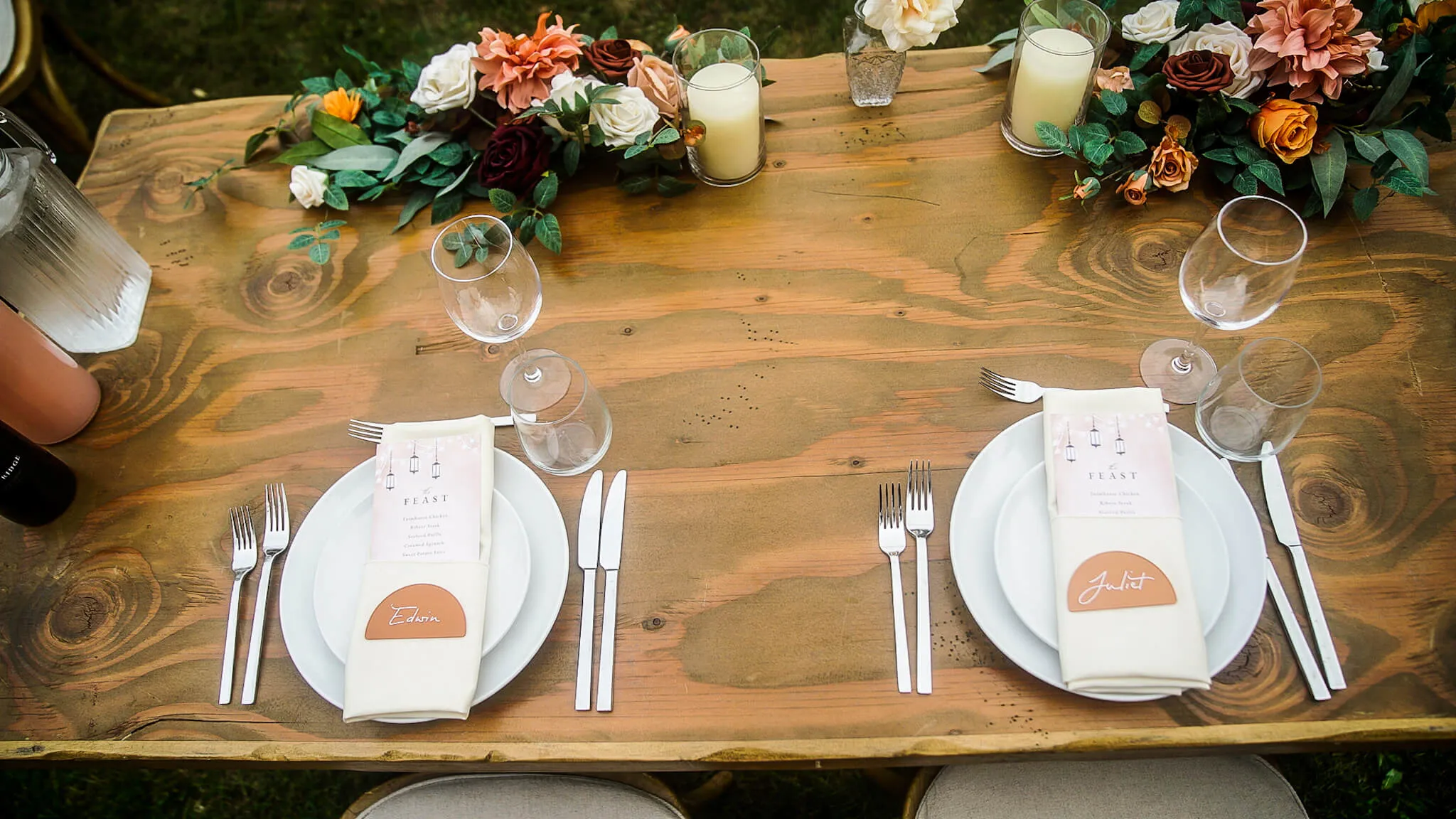 Overhead of two rustic place settings with menus and name cards