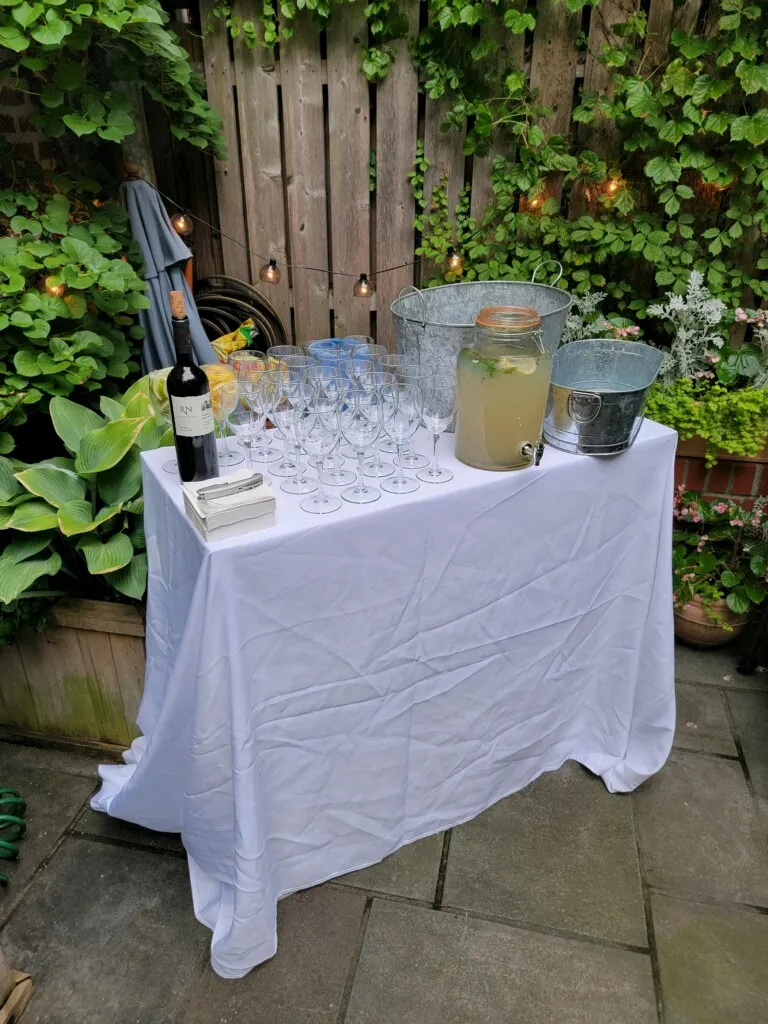 Outdoor drink station with wine glasses and a lemonade dispenser