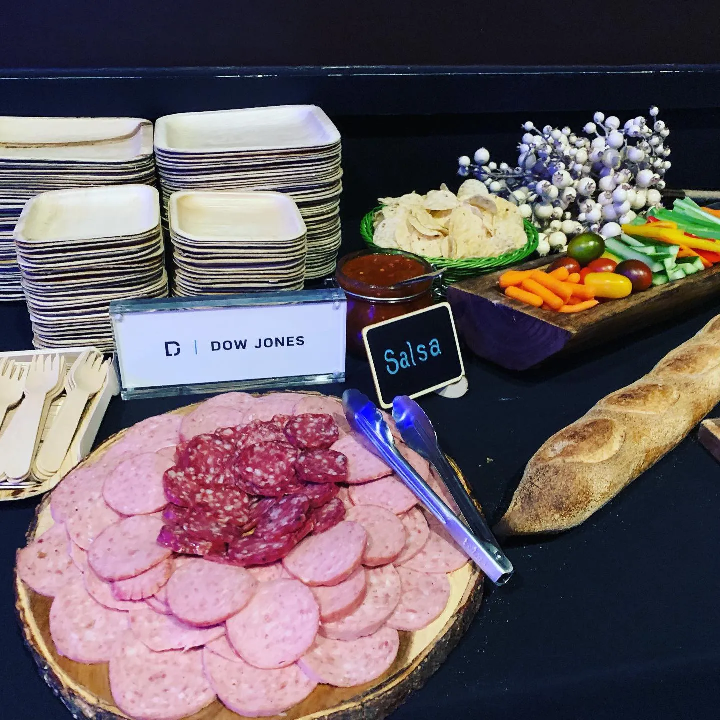 Charcuterie board of sliced sausage and salami with crudités and baguette