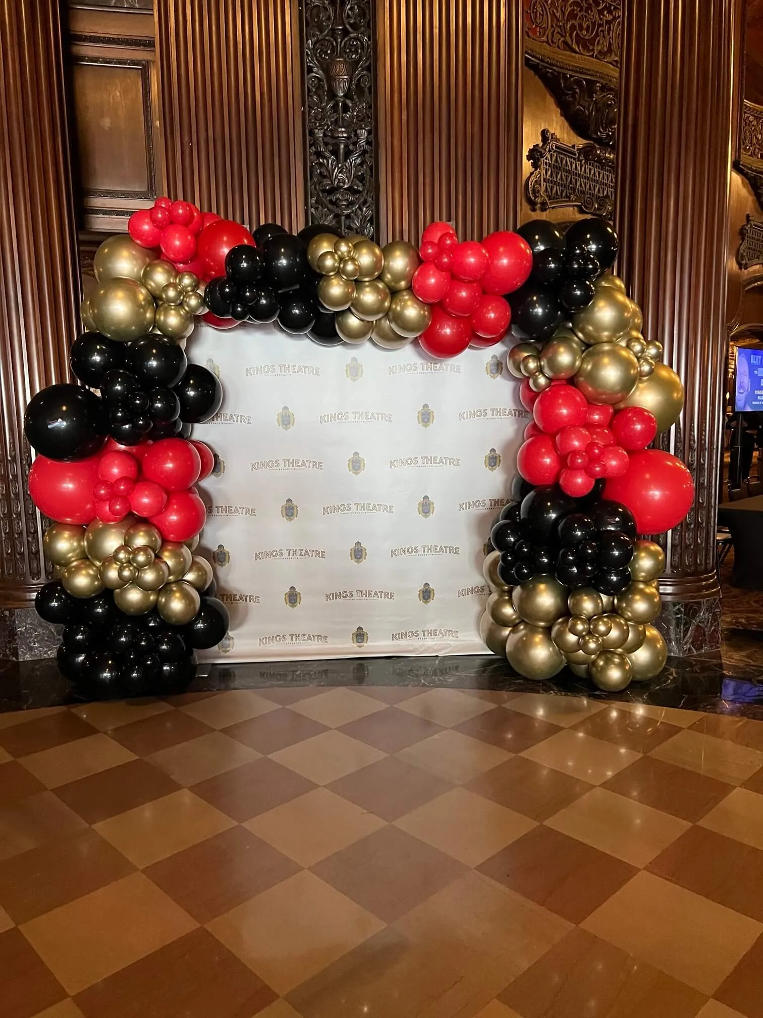 Balloon arch around a Kings Theatre step-and-repeat backdrop